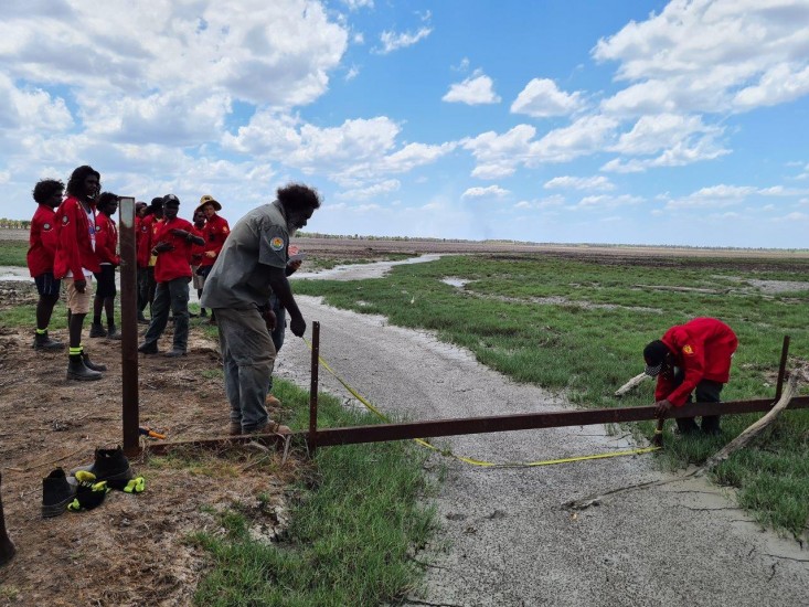 Neville Gulaygulay and Learning on Country students measuring a buffalo swim channel.